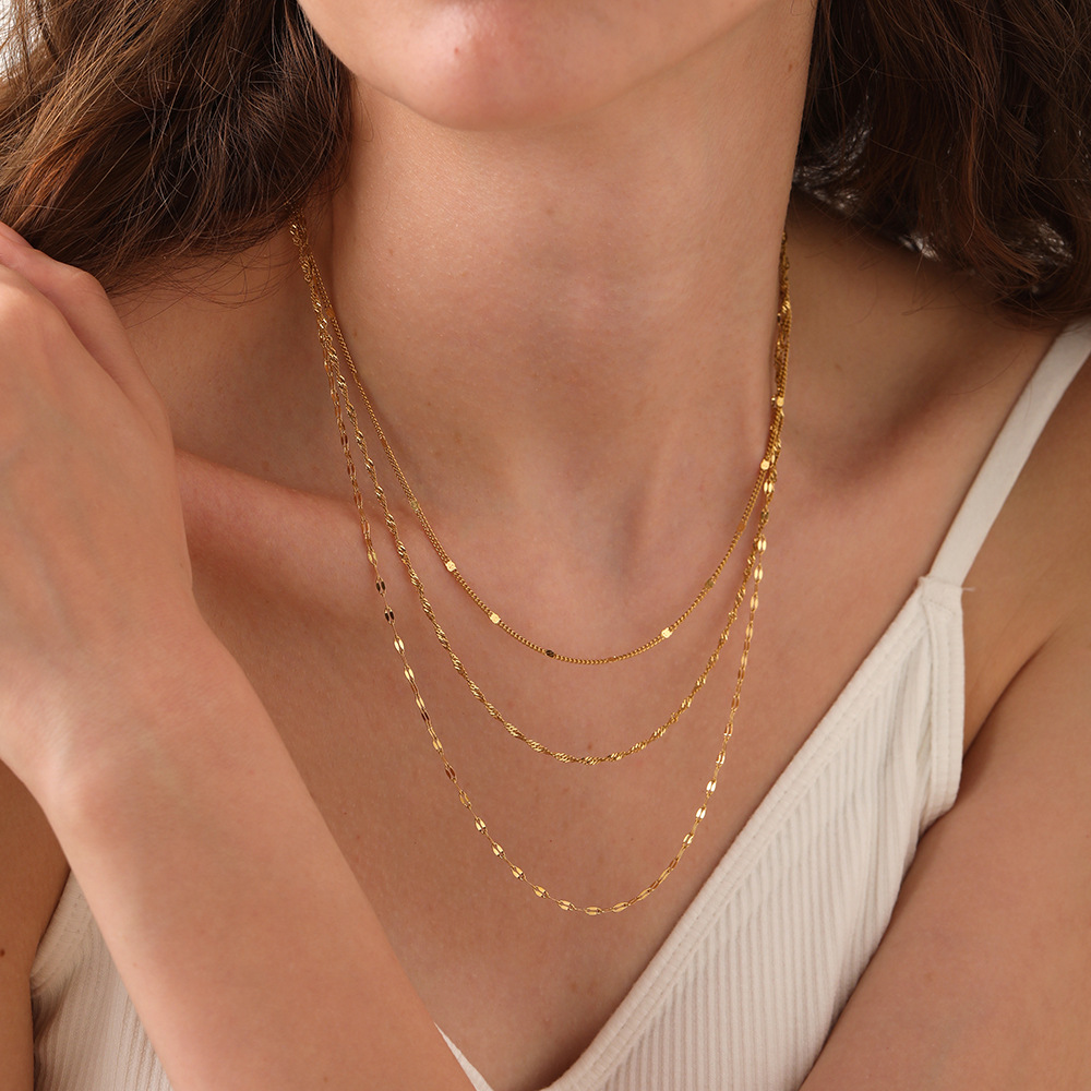 Model wearing a layered three-chain 18K gold plated necklace